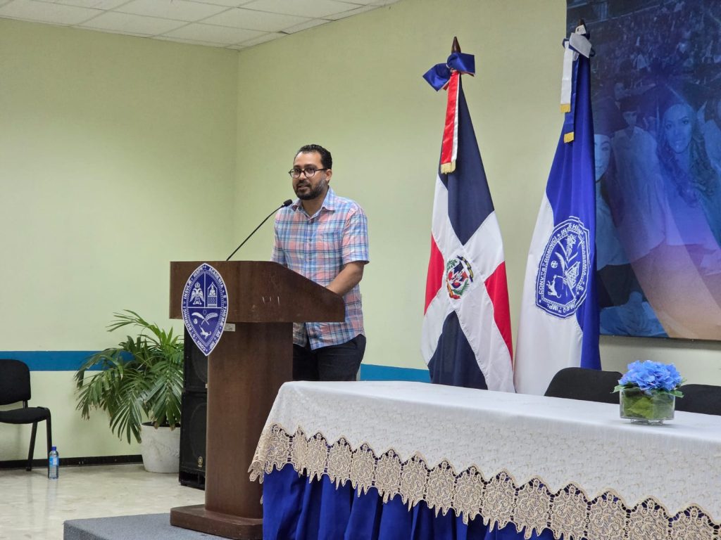 El Dr. Faustino Medina lee uno de sus poemas en la celebración del Día del Poeta en la UASD Santiago